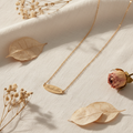 Personalised gold name necklace on white linen background