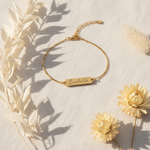 Personalised gold name bracelet on white linen background